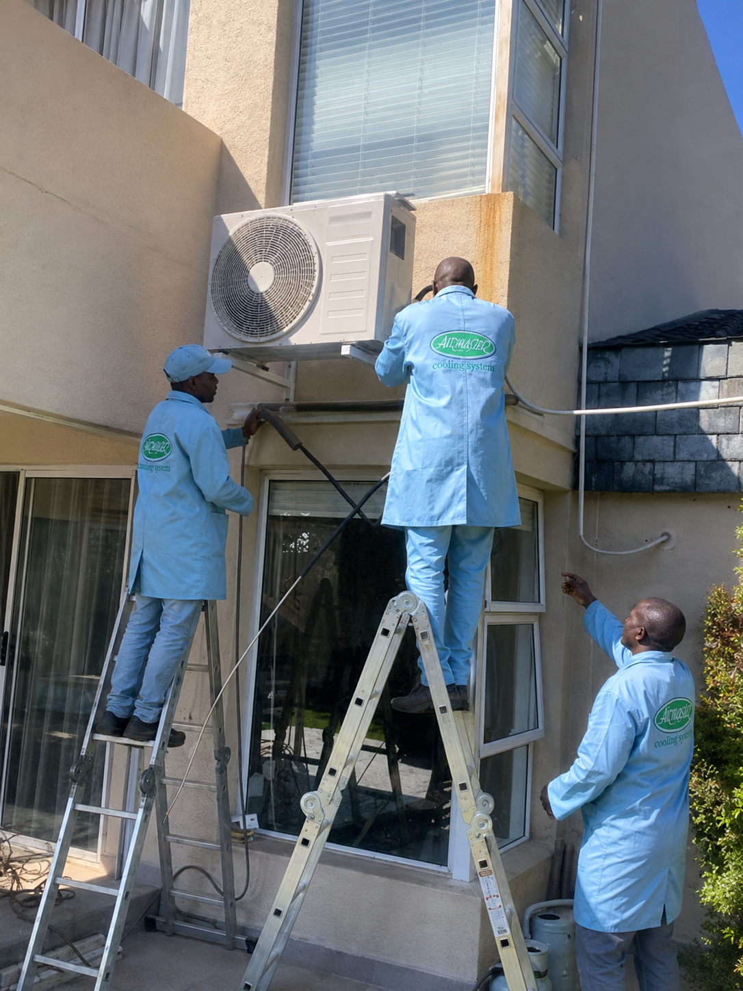 Airmaster technicians servicing an outdoor air-conditioning unit